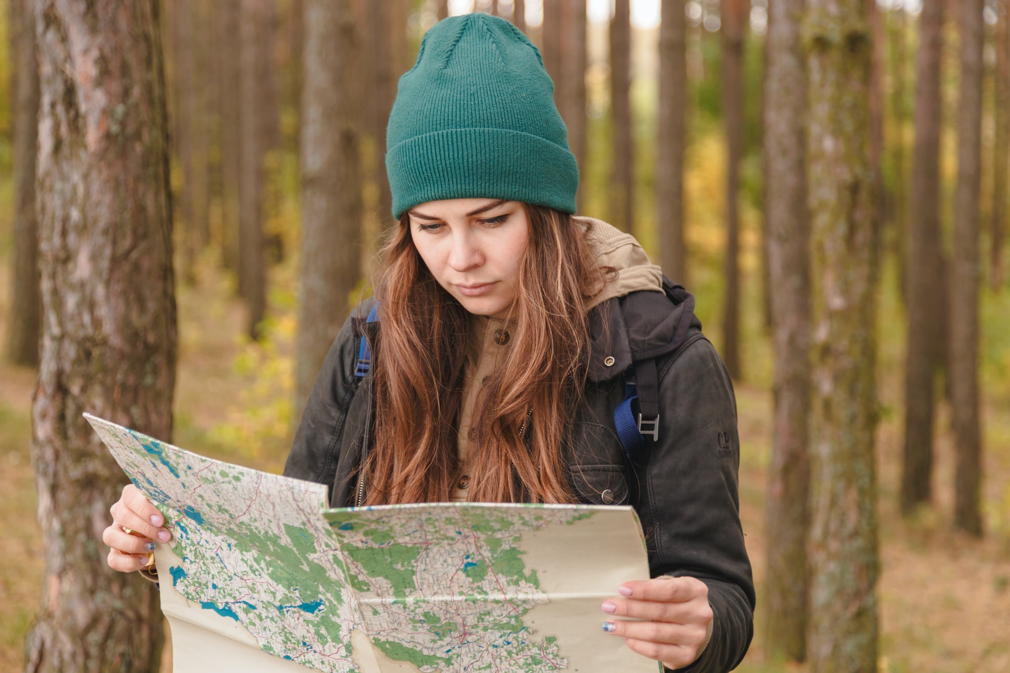 woman-with-travel-map-and-backpack-in-pine-forest.jpg